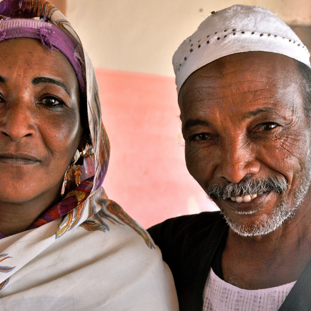Get Involved 2 A couple looks warmly at the camera, dressed in a hijab and a head covering